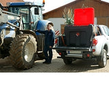 Person standing next to a white truck with a red toolbox on a gravel surface.