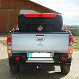 Back view of a silver pickup truck with a trailer attached, parked outdoors.